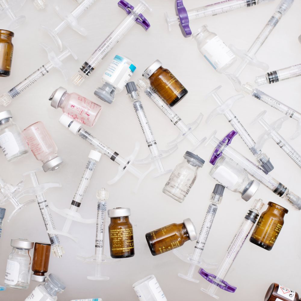 Assorted medical syringes and vials used for injectable aesthetic treatments such as Botox and dermal fillers, displayed on a clean white surface.